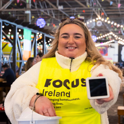Volunteer holding a sum up device at a Focus Ireland Event